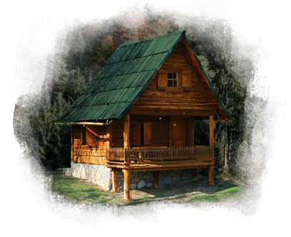 Small, cozy log cottage with a peaked pine-green roof. The front includes a deck area and the cottage features many classic 4-pane glass windows.